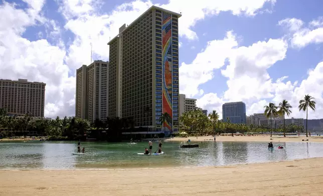 FILE - People swim in the lagoon in front of the Hilton Hawaiian Village resort in Honolulu on Saturday, Sept. 4, 2021. (AP Photo/Caleb Jones, File)