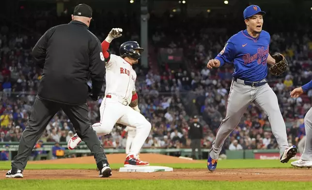New York Mets pitcher Kodai Senga, right, reacts as Boston Red Sox's Jarren Duran, center, safely reaches first base on a throwing error in the fourth inning of a baseball game at Fenway Park, Monday, May 19, 2025, in Boston. (AP Photo/Charles Krupa)