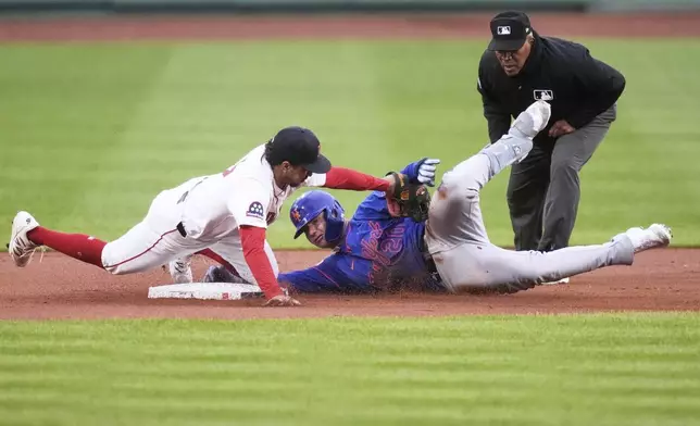 Boston Red Sox second baseman David Hamilton, left, tags out New York Mets' Pete Alonso, center, who was trying to advance to second on his single during the first inning of a baseball game at Fenway Park, Monday, May 19, 2025, in Boston. (AP Photo/Charles Krupa)