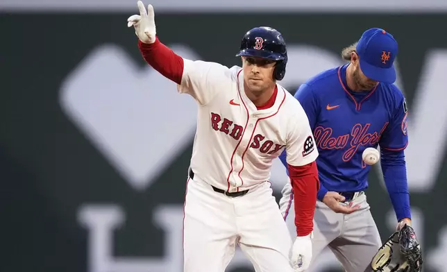 Boston Red Sox's Alex Bregman, left, celebrates after his double in the third inning of a baseball game against the New York Mets at Fenway Park, Monday, May 19, 2025, in Boston. (AP Photo/Charles Krupa)