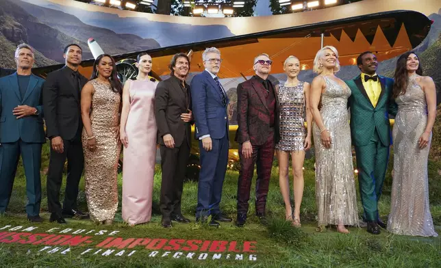 Esai Morales, from left, Greg Tarzan Davis, Angela Bassett, Hayley Atwell, Tom Cruise, director Christopher McQuarrie, Simon Pegg, Pom Klementieff, Hannah Waddingham, Tramell Tillman, and Mariela Garriga pose for photographers upon arrival at the premiere of the film 'Mission: Impossible - The Final Reckoning' on Thursday, May 15, 2025, in London. (Photo by Alberto Pezzali/Invision/AP)