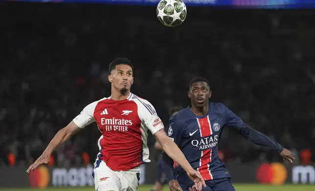 Arsenal's William Saliba, left, challenges PSG's goalkeeper PSG's Ousmane Dembele during the Champions League semifinal, second leg soccer match between Paris Saint-Germain and Arsenal at the Parc des Princes in Paris, Wednesday, May 7, 2025. (AP Photo/Thibault Camus)