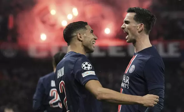 PSG's Fabian Ruiz, right, celebrates with team mate Achraf Hakimi after scoring his side's opening goal the Champions League semifinal, second leg soccer match between Paris Saint-Germain and Arsenal at the Parc des Princes in Paris, Wednesday, May 7, 2025. (AP Photo/Aurelien Morissard)