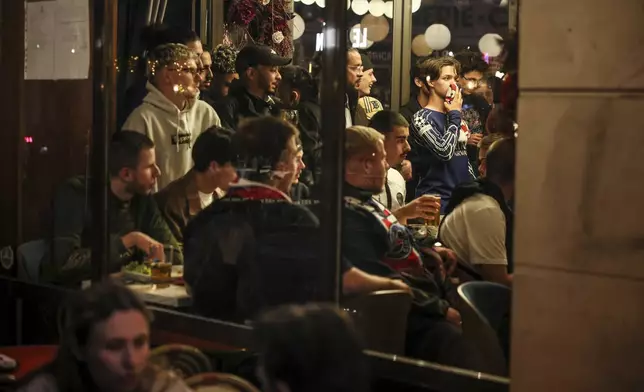PSG supporters gather in a bar to watch the Champions League semifinal, second leg soccer match between Paris Saint-Germain and Arsenal being played at the Parc des Princes in Paris, Wednesday, May 7, 2025. (AP Photo/Thomas Padilla)