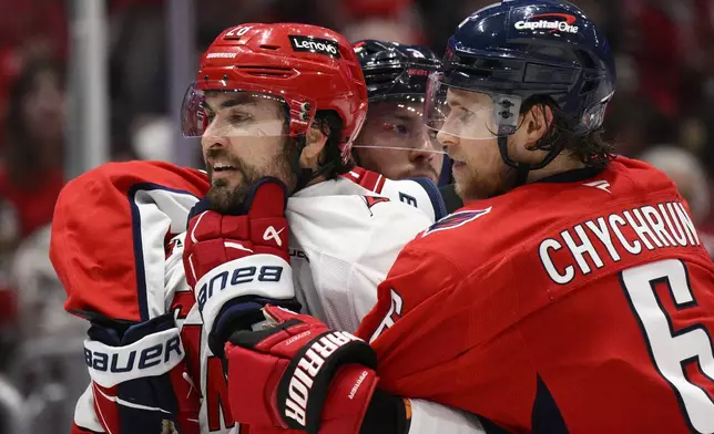 Washington Capitals defenseman Jakob Chychrun (6) scuffles with Carolina Hurricanes left wing William Carrier, left, in the second period of Game 1 of a second-round NHL hockey playoff series Tuesday, May 6, 2025, in Washington. (AP Photo/Nick Wass)
