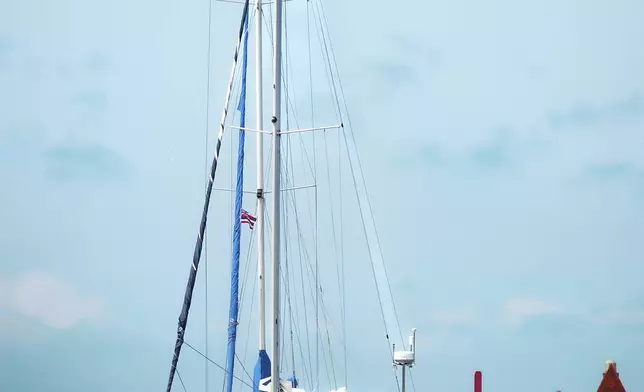 Oliver Widger, (back of boat) a 29-year-old Oregon man who sailed from Oregon to Hawaii, arrives at the Waikiki Yacht Club, on Saturday, May 24, 2025 in Waikiki, Hawaii. (AP Photo/Michelle Bir)
