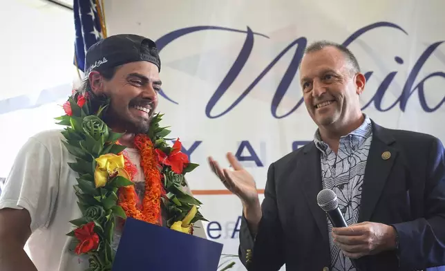 Governor Josh Green presents a proclamation to Oliver Widger, 29-year-old Oregon man who sailed from Oregon to Hawai'i, on Saturday, May 24, 2025 in Waikiki, Hawaii. (AP Photo/Michelle Bir)