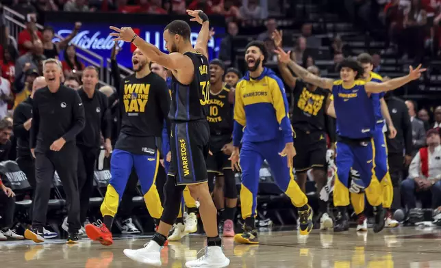Golden State Warriors players react to Buddy Hield's (7) first quarter buzzer-beater against the Houston Rockets in Game 7 of an NBA basketball first-round playoff series in Houston, Sunday, May 4, 2025. (Carlos Avila Gonzalez/San Francisco Chronicle via AP)