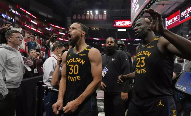 Golden State Warriors' Stephen Curry (30) and Draymond Green (23) celebrate after Game 7 of an NBA basketball first-round playoff series against the Houston Rockets Sunday, May 4, 2025, in Houston. (AP Photo/Ashley Landis)