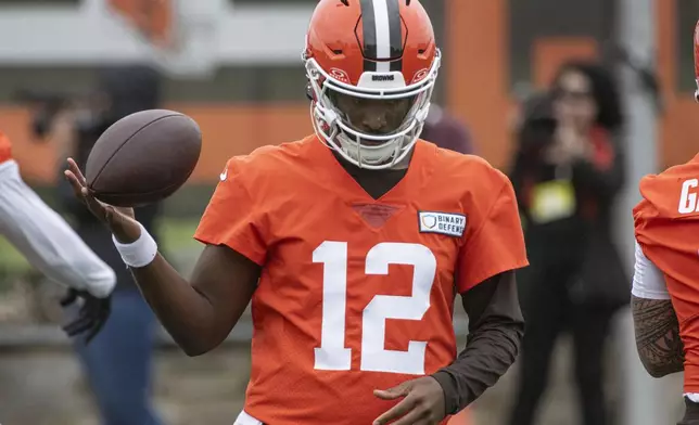 Cleveland Browns quarterback Shedeur Sanders (12) twirls the ball during an NFL football practice, Wednesday, May 28, 2025, in Berea, Ohio. (AP Photo/Phil Long)