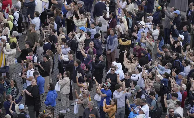 People watch as the black smoke billows from the chimney of the Sistine Chapel where 133 cardinals are gathering on the second day of the conclave to elect a successor to late Pope Francis, at the Vatican, Thursday, May 8, 2025(AP Photo/Markus Schreiber)