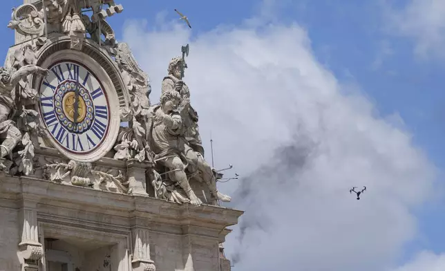 A drone flies as black smoke billows from the chimney of the Sistine Chapel where 133 cardinals are gathering on the second day of the conclave to elect a successor to late Pope Francis, at the Vatican, Thursday, May 8, 2025. (AP Photo/Luca Bruno)
