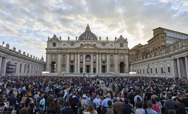 People wait for the smoke billowing from the chimney of the Sistine Chapel, where 133 cardinals are gathering on the first day of the conclave, indicating that a successor of late Pope Francis was elected or not, Wednesday, May 7, 2025. (AP Photo/Bernat Armangue)