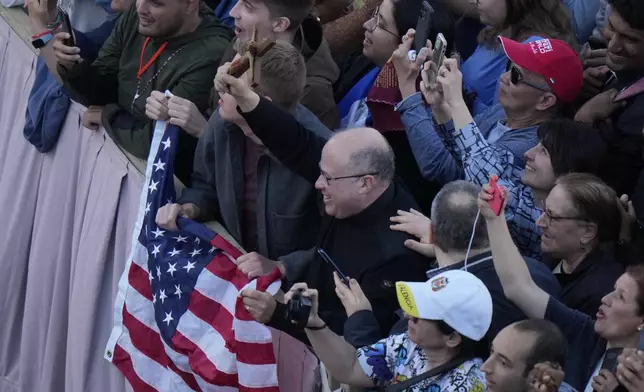 People react after Cardinal Dominique Mamberti announced the election of Cardinal Robert F. Prevost as the 267th pope, choosing the name of Pope Leo XIV, at the Vatican, Thursday, May 8, 2025. (AP Photo/Luca Bruno)