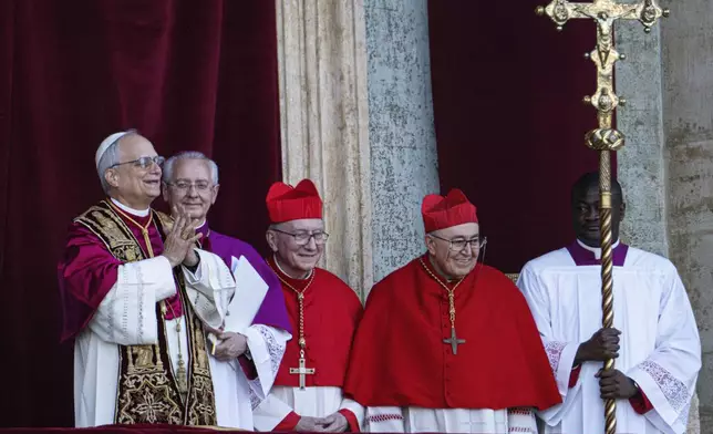 Newly elected Pope Leo XIV, left, formerly Cardinal Robert Francis Prevost, appears on the central loggia of St. Peter's Basilica at the Vatican shortly after his election as the 267th pontiff of the Roman Catholic Church, Thursday, May 8, 2025. (AP Photo/Domenico Stinellis)