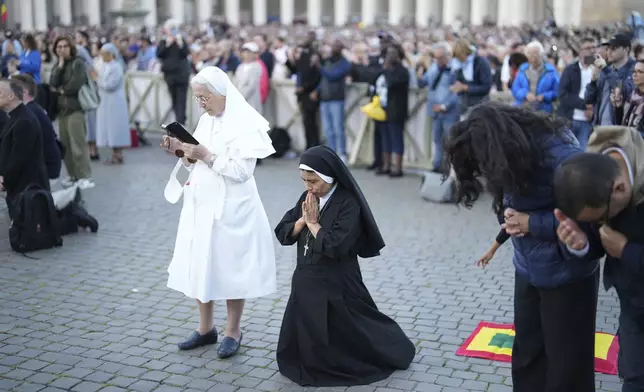 Sor Clara a nun from Peru prays during the speech of the newly elected Pope Leo XIV at the Vatican, Thursday, May 8, 2025. (AP Photo/Francisco Seco)