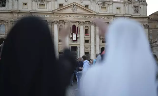 Nuns react during the speech of the newly elected Pope Leo XIV at the Vatican, Thursday, May 8, 2025. (AP Photo/Francisco Seco)