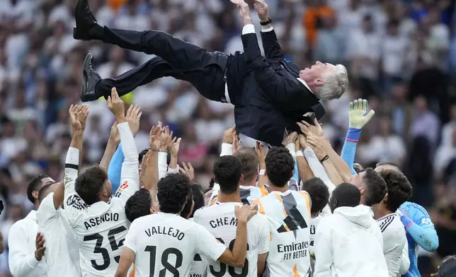 Real Madrid's head coach Carlo Ancelotti is tossed into the air by his players after defeating Real Sociedad at the end of a Spanish La Liga soccer match, at Santiago Bernabeu stadium in Madrid, Saturday, May 24, 2025. (AP Photo/Cesar Cebolla)
