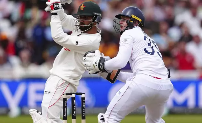 Zimbabwe's Sikandar Raza, left, bats on day three of the Rothesay International Test match between England and Zimbabwe at Trent Bridge, Nottingham, England, Saturday, May 24, 2025. (Mike Egerton/PA via AP)