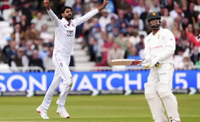 England's Shoaib Bashir, left, celebrates taking the wicket of Zimbabwe's Sikandar Raza on day three on day three of the Rothesay International Test match between England and Zimbabwe at Trent Bridge, Nottingham, England, Saturday, May 24, 2025. (Mike Egerton/PA via AP)