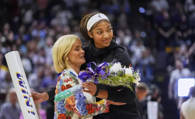 Chicago Sky forward Angel Reese hugs her former coach, LSU's Kim Mulkey, as she presents Reese flowers before a WNBA exhibition basketball game against Brazil in Baton Rouge, La., Friday, May 2, 2025. (AP Photo/Gerald Herbert)