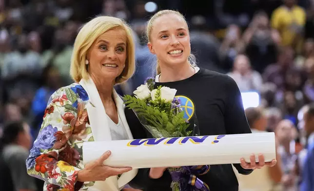 LSU women's basketball head coach Kim Mulkey presents flowers to her former player, Chicago Sky guard Hailey Van Lith, before a WNBA exhibition basketball game against Brazil in Baton Rouge, La., Friday, May 2, 2025. (AP Photo/Gerald Herbert)