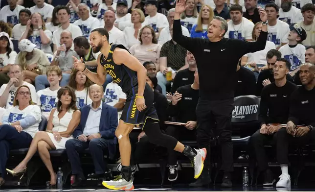 Golden State Warriors guard Stephen Curry (30), left, gestures after making a 3-point shot as Minnesota Timberwolves head coach Chris Finch, right, reacts during the first half of Game 1 of an NBA basketball second-round playoff series, Tuesday, May 6, 2025, in Minneapolis. (AP Photo/Abbie Parr)