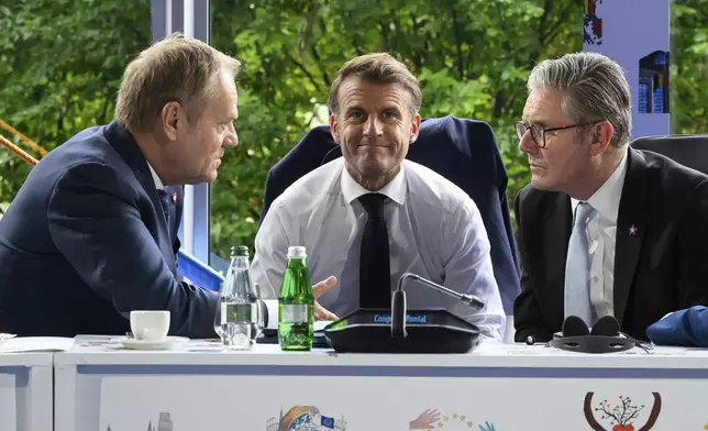 From left, Poland's Prime Minister Donald Tusk, France's President Emmanuel Macron, and Britain's Prime Minister Keir Starmer speak during the Ukraine security meeting at the 6th European Political Community summit Friday May 16, 2025 in Tirana, Albania. (Leon Neal/Pool via AP)