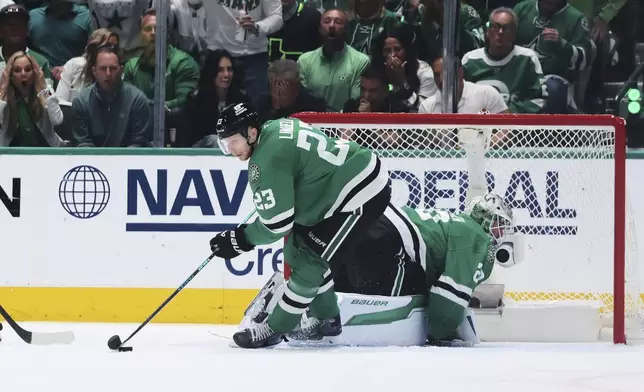 Dallas Stars' Esa Lindell (23) takes control of the puck after a save by goaltender Jake Oettinger, rear, in the third period of Game 6 of a second-round NHL hockey playoff series against the Winnipeg Jets in Dallas, Saturday, May 17, 2025. (AP Photo/Gareth Patterson)