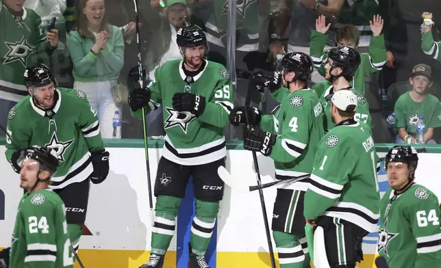 Dallas Stars' Thomas Harley (55) celebrates with teammates after harley scored in overtime of Game 6 of a second-round NHL hockey playoff series against the Winnipeg Jets in Dallas, Saturday, May 17, 2025. (AP Photo/Gareth Patterson)