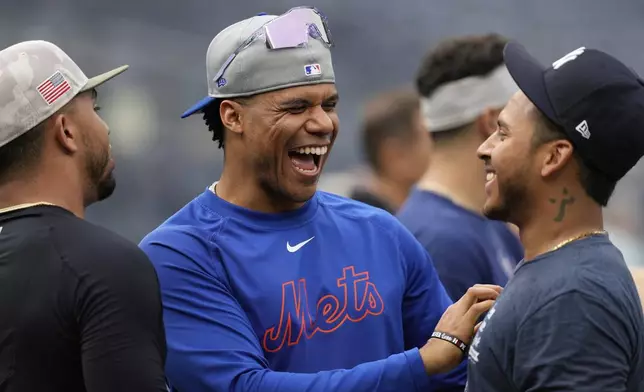 New York Mets' Juan Soto, center, talks with New York Yankees' Jorbit Vivas before a baseball game Friday, May 16, 2025, in New York. (AP Photo/Seth Wenig)