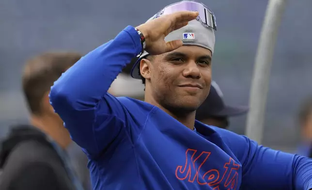 New York Mets' Juan Soto greets someone on the field before a baseball against the New York Yankees game Friday, May 16, 2025, in New York. (AP Photo/Seth Wenig)