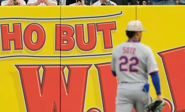 Fans react as New York Mets' Juan Soto (22) makes his way to right field during the first inning of a baseball game against the New York Yankees, Friday, May 16, 2025, in New York. (AP Photo/Seth Wenig)