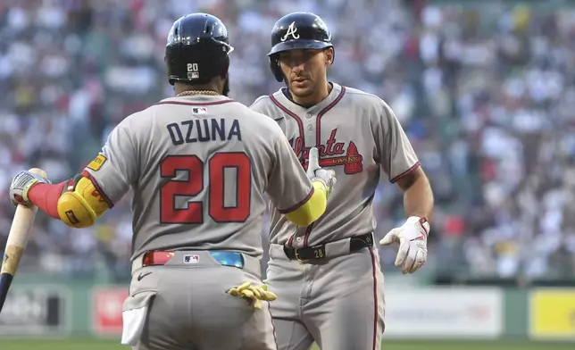 Atlanta Braves' Matt Olson, right, celebrates with Marcell Ozuna, left, after scoring on his two-run home run in the first inning of a baseball game against the Boston Red Sox, Saturday, May 17, 2025, in Boston. (AP Photo/Steven Senne)