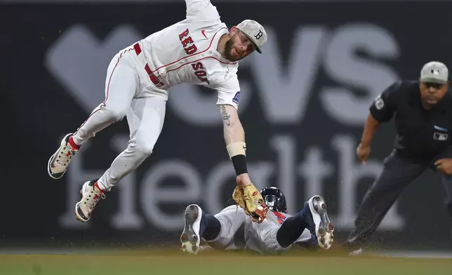 Boston Red Sox shortstop Trevor Story, top left, is unable to get his glove on Atlanta Braves' Eli White, bottom, as White steals second base in the fourth inning of a baseball game, Saturday, May 17, 2025, in Boston. (AP Photo/Steven Senne)