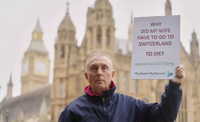 Pro-assisted dying campaigners Dave Sowry holds a placard outside Parliament ahead of Fridays report stage in the Commons on The Terminally Ill Adults (End of Life) Bill, which is expected to see MPs vote on further amendments, in Westminster in London, Thursday, May 15, 2025. (AP Photo/Kirsty Wigglesworth)