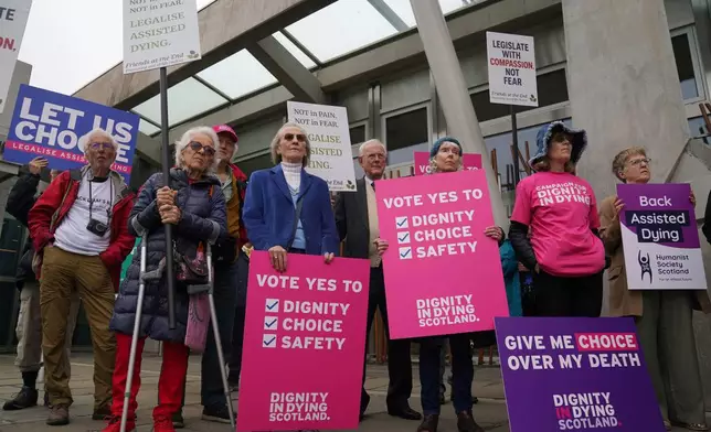 Members of Dignity in Dying Scotland and members of the Assisted Dying Coalition gather as they show their support for a change in the law on assisted dying outside the Scottish Parliament in Edinburgh, ahead of the debate and vote on the Assisted Dying for Terminally Ill Adults (Scotland) Bill Tuesday, May 13, 2025. (Andrew Milligan/PA via AP)