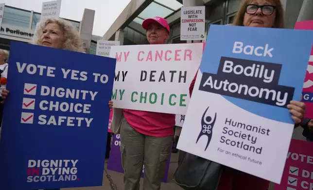 Members of Dignity in Dying Scotland and members of the Assisted Dying Coalition gather as they show their support for a change in the law on assisted dying outside the Scottish Parliament in Edinburgh, ahead of the debate and vote on the Assisted Dying for Terminally Ill Adults (Scotland) Bill Tuesday, May 13, 2025. (Andrew Milligan/PA via AP)