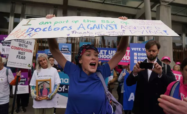 Doctor Geri Hignett protests against a change in the law on assisted dying outside the Scottish Parliament in Edinburgh, ahead of the debate and vote on the Assisted Dying for Terminally Ill Adults (Scotland) Bill Tuesday, May 13, 2025. (Andrew Milligan/PA via AP)
