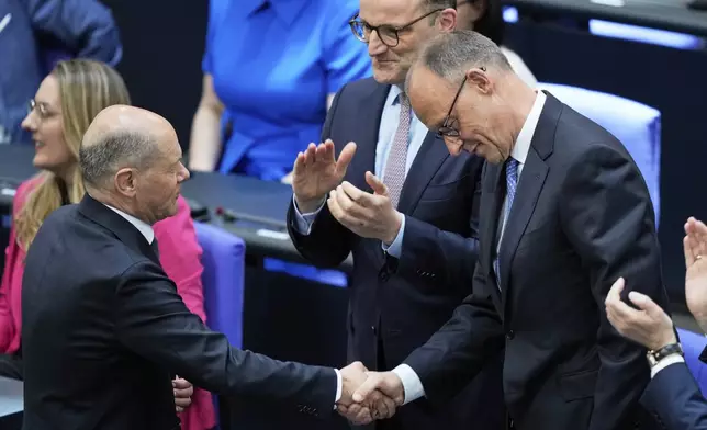 Leader of the Christian Democrats Friedrich Merz is congratulated by outgoing Chancellor Olaf Scholz after being elected new chancellor at the German federal parliament, Bundestag, at the Reichstag building in Berlin, Germany, Tuesday, May 6, 2025. (AP Photo/Ebrahim Noroozi)
