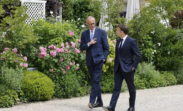 German Chancellor Friedrich Merz, left, speaks with French President Emmanuel Macron in the garden of the Elysee palace in Paris, Wednesday, May 7, 2025.(Ludovic Marin, Pool via AP)