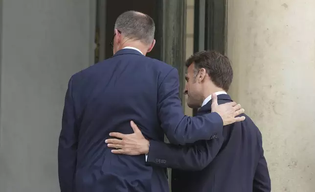 French President Emmanuel Macron, right, and German Chancellor Friedrich Merz enter the Elysee Palace, Wednesday, May 7, 2025 in Paris. (AP Photo/Michel Euler)
