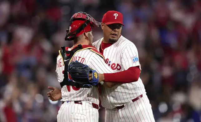 Philadelphia Phillies pitcher Carlos Hernández, right, and catcher J.T. Realmuto celebrate after the Phillies won a baseball game against the Washington Nationals, Wednesday, April 30, 2025, in Philadelphia. (AP Photo/Matt Slocum)