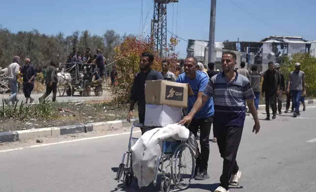 Palestinians carry boxes and bags containing food and humanitarian aid packages delivered by the Gaza Humanitarian Foundation, a U.S.-backed organization approved by Israel, in Khan Younis, southern Gaza Strip, on Thursday, May 29, 2025. (AP Photo/Abdel Kareem Hana)