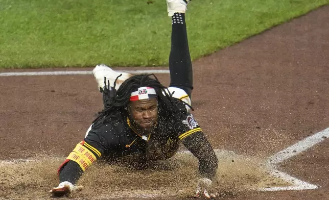 Pittsburgh Pirates' Oneil Cruz scores from second on a single by Bryan Reynolds off Cincinnati Reds pitcher Nick Martinez during the sixth inning of a baseball game in Pittsburgh, Tuesday, May 20, 2025. (AP Photo/Gene J. Puskar)