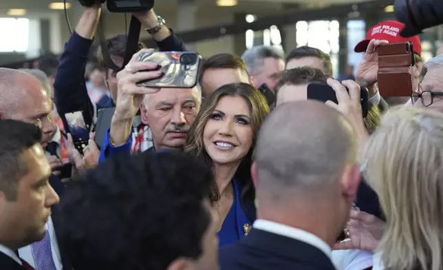 Homeland Security Secretary Kristi Noem, center, takes a selfie as she attends at the Conservative Political Action Conference, CPAC, Tuesday, May 27, 2025, in Jasionka, Poland. (AP Photo/Alex Brandon, Pool)