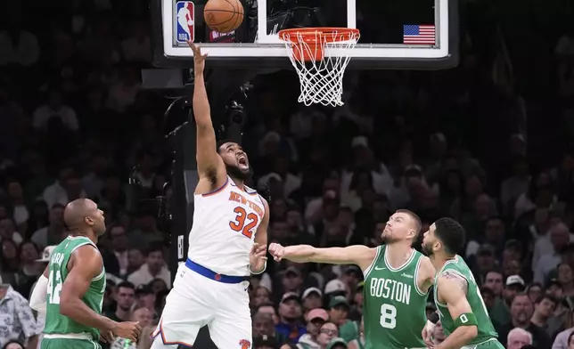 New York Knicks center Karl-Anthony Towns (32) takes a shot against the Boston Celtics during the first half of Game 2 of an NBA basketball second-round playoff series, Wednesday, May 7, 2025, in Boston. (AP Photo/Charles Krupa)