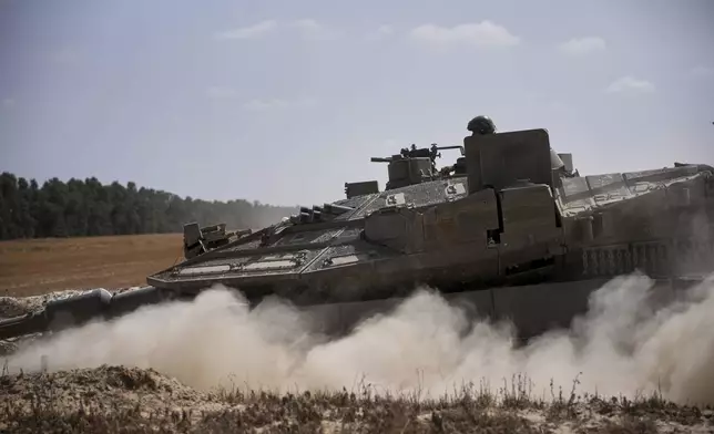 Israeli forces move along the border with the Gaza Strip, in southern Israel, Monday, May 19, 2025. (AP Photo/Ohad Zwigenberg)