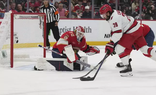 Florida Panthers goaltender Sergei Bobrovsky (72) deflects a shot on goal by Carolina Hurricanes left wing William Carrier (28) during the first period in Game 4 of of the NHL hockey Stanley Cup Eastern Conference finals, Monday, May 26, 2025, in Sunrise, Fla. (AP Photo/Lynne Sladky)