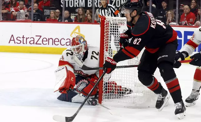 Florida Panthers goaltender Sergei Bobrovsky (72) pokes the puck away from the stick of Carolina Hurricanes' Jesperi Kotkaniemi (82) during the second period of Game 5 of the NHL hockey Stanley Cup Eastern Conference finals in Raleigh, N.C., Wednesday, May 28, 2025. (AP Photo/Karl DeBlaker)